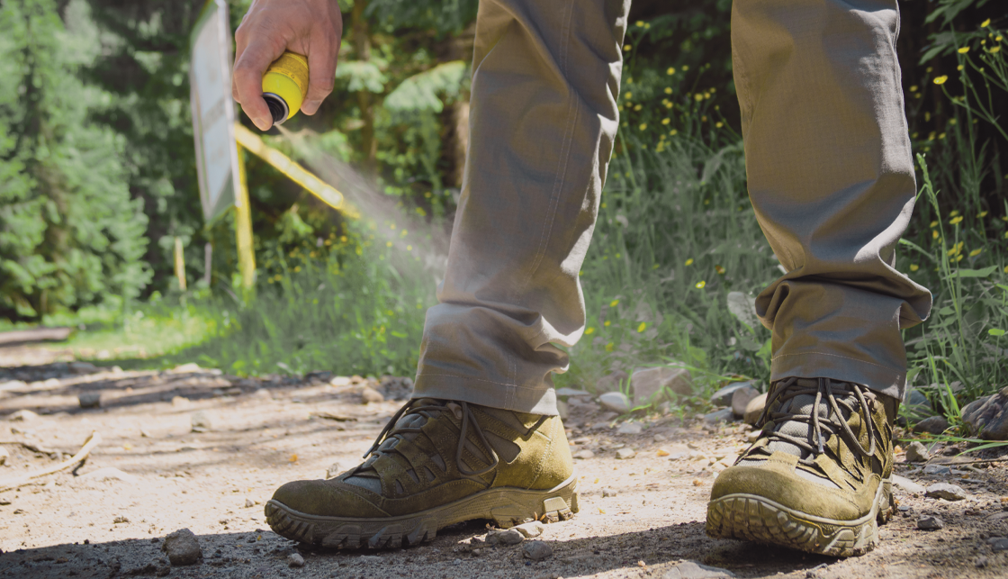 [라이프케어] 등산 하기 전 등산바지와 등산화를 신은 사람이 진드기 기피제를 뿌리고 있습니다.