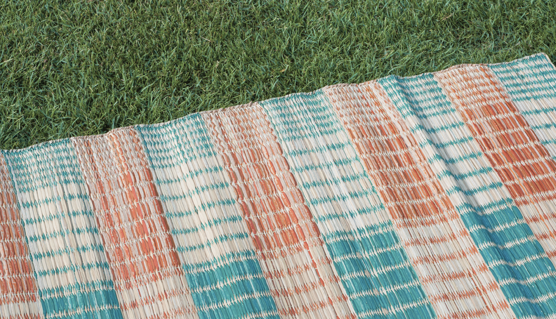 [라이프케어] 푸른 잔디 위에 돗자리가 펼쳐져 있습니다.